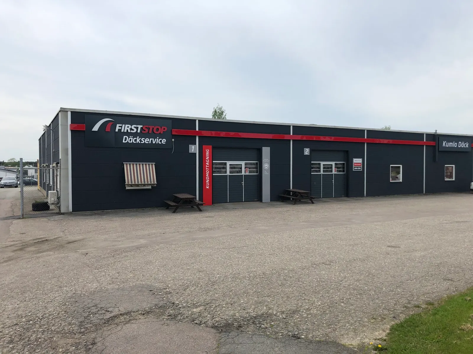 Kumla Däcks verkstad på Sörbyvägen 4 med rött band längs fasaden och portarna 1 och 2